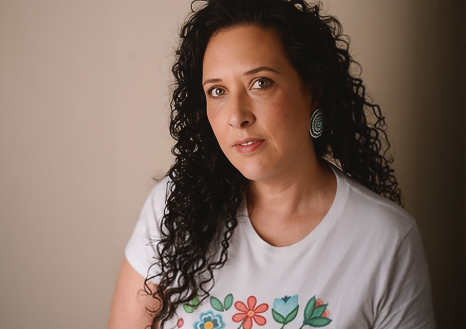 Woman wearing a white t-shirt with colorful floral designs against a plain background
